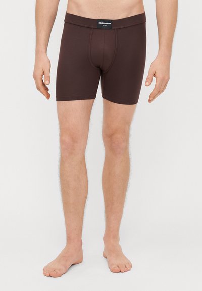 Brune boxershorts lavet af strækstof, med en blød talje med brandetiket, tætsiddende pasform og et design, der går til midten af låret.