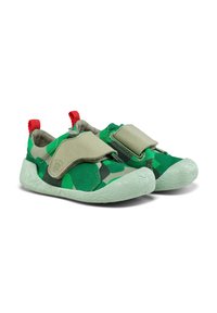 Scarpe in tela verde mimetico con una morbida suola in gomma verde chiaro, dotate di una grande fascia in velcro grigia e linguette rosse sul retro.