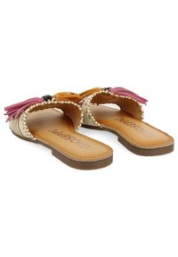 Platta sandaler med en beige bas, prydda med färgglada fransar i rosa och orange, samt flätade detaljer längs sidorna. Lädret innersula.