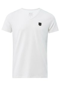 Weißes V-Ausschnitt-T-Shirt aus weichem Stoff. Verfügt über ein kleines schwarzes Logo-Patch auf der Brust. Kurze Ärmel und lockere Passform.