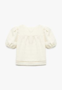 Blusa blanca con mangas cortas abullonadas, tela texturizada y rayas horizontales. Cuenta con un ribete de encaje en el dobladillo y un escote redondo.