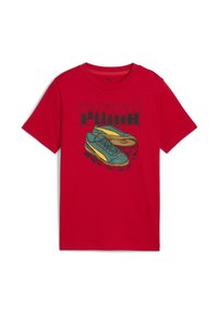 Rode katoenen t-shirt met een afbeelding van blauwe en gele sneakers met een zwarte omtrek. Korte mouwen en ronde halsontwerp.