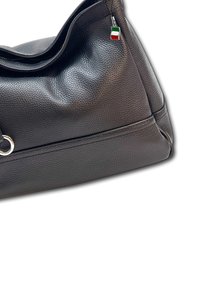 Sac en cuir noir avec une finition texturée, doté d'un accent en métal argenté et d'un petit charme en forme de drapeau italien tricolore attaché.