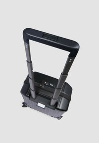 Schwarzer Hartschalenkoffer mit Teleskopgriff, Reißverschluss, Zahlenschloss und Gummirädern. Glatte Oberflächenstruktur.