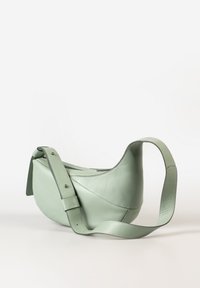 Groene leren schoudertas met een gladde textuur, gebogen vorm en verstelbare schouderband. Heeft een minimalistisch ontwerp en subtiele stiksels.