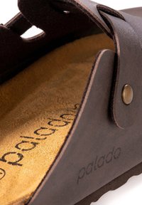 Braune Leder-Sandale mit einer strukturierten Oberseite und einer weichen, beigefarbenen Korkeinlegesohle. Verfügt über ein markantes Logo und metallische Akzente für einen sicheren Sitz.