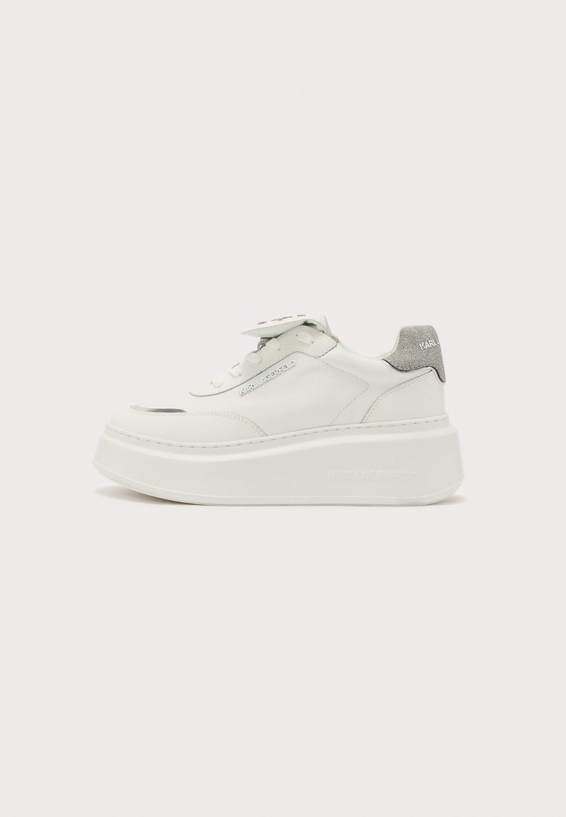 White leather sneaker with a thick platform sole, featuring a grey accent on the heel and a logo tag on the tongue. Smooth texture.
