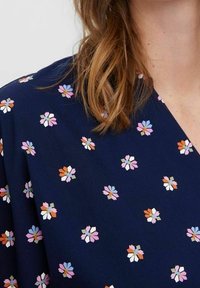 Navy sinivuori, jossa on hajallaan pieniä kukkakuvioita vaaleanpunaisina, valkoisina ja vihreinä; kevyt, sileä rakenne; V-päällyste.