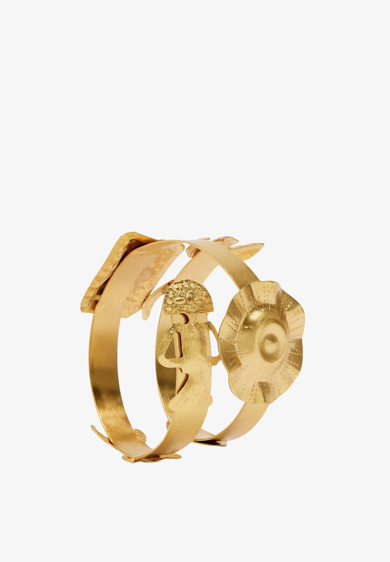 Złocisty, wielopaskowy bransoletka z dekoracyjnymi elementami: kwiat, sylwetka osoby oraz teksturowany wzór kwadratu. Gładkie i wypolerowane wykończenie.