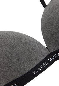 Sujetador gris acolchado con tela suave y texturizada. Presenta una banda negra con "YSABEL MORATA" en texto blanco. Las tirantes ajustables mejoran el ajuste.