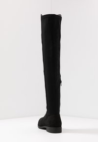 Botas negras por encima de la rodilla con un diseño elegante, hechas de una mezcla de tela suave y gamuza blanda, con un cierre lateral y punta redonda.