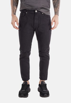 Jeans neri a gamba tapered con vestibilità slim, caratterizzati da chiusura frontale con bottone, cinque tasche e dettagli strappati sulle ginocchia.