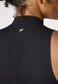 Top senza maniche nero con colletto alto, texture liscia, caratterizzato da una cucitura verticale e un piccolo dettaglio del logo bianco sul retro.