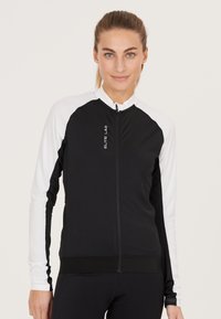 Schwarz-weiße Fahrradjacke mit tailliertem Design, durchgehendem Reißverschluss und strukturierten Ärmeln. Mit Logo auf der Brust und elastischem Taillenbund.