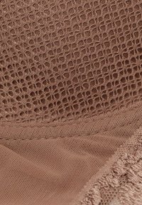 Brązowa teksturowana tkanina z siatkowym wzorem o geometrycznych kształtach i gładkimi akcentami, tworząc efekt warstwowy.