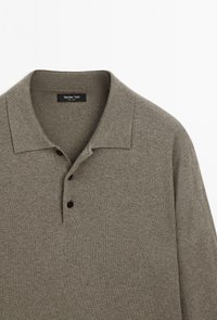 Grijs gebreid poloshirt met lange mouwen en kraag, voorzien van drie donkere knopen, toont de bovenkant aan de voorkant en het merkje binnen de hals.