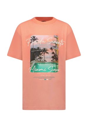 Perzikkleurig T-shirt met korte mouwen en een bedrukte afbeelding van palmbomen en een zwembad. Tekst bevat "Florida Sunsets" en "Miami Shores".