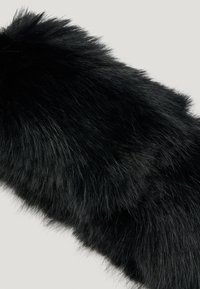 Faux fur negru cu o textură densă și moale, având lungimi variate. Prezintă o finisare ușor lucioasă, cu firi lungi și zemoase.