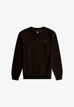 Sudadera negra con cuello redondo, puños y dobladillo acanalados. Presenta un pequeño logo en el pecho y un material suave y texturizado.