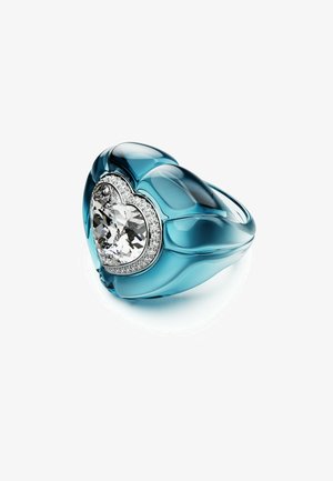 Anillo en forma de lágrima en azul translúcido con un centro de cristal claro en forma de corazón, rodeado de un brillante borde plateado.