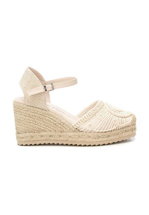 Sandalia espadrille de cuña beige con tacón de yute tejido, puntera cerrada bordada y correa ajustable en el tobillo con una pequeña hebilla.