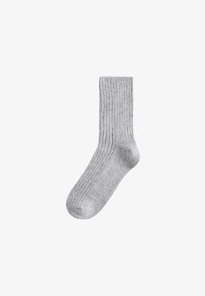 Light gray, ribbed, mid-calf sock laid flat, showing texture and shape clearly against a white background.