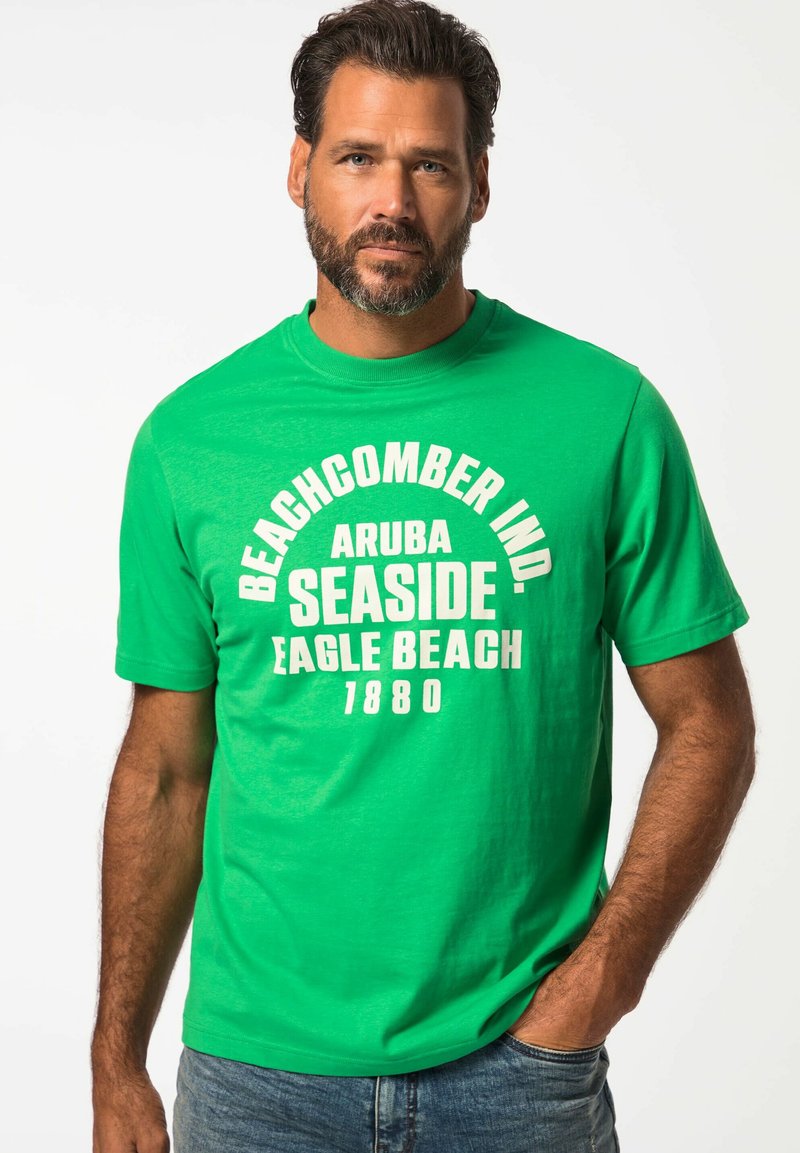 Zelené bavlněné tričko s tučným bílým textem: "BEACHCOMBER IND. ARUBA SEASIDE EAGLE BEACH 1880." Klasický kulatý výstřih a krátké rukávy.