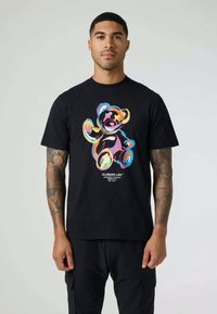T-shirt preta com um gráfico de urso colorido em várias tonalidades e logotipo em texto. Material em algodão, com mangas curtas e corte casual.