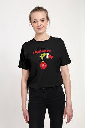 Schwarzes T-Shirt mit einem bunten Motiv, auf dem der Text „Merry GRINCHMAS!“, eine grüne Hand und ein rotes Ornament mit der Aufschrift „The Grinch“ zu sehen sind.