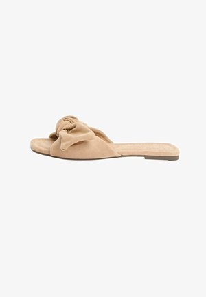Beige suede flat slide sandal with a soft knotted bow detail on top and a flat sole.