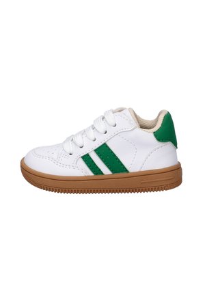 Witte kindersneaker met groene strepen, groene hielband, witte veters en een bruine rubberen zool op een witte achtergrond.