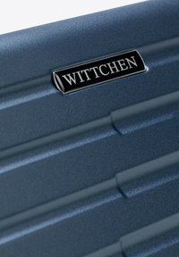 Valigia rigida Wittchen, blu navy con superficie texture, caratterizzata da linee verticali e scanalate e da una piastra con logo argentato.