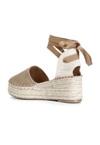 Espadrillas in tela color sabbia con suola in juta intrecciata, open back e lacci in raso marrone. Presentano un tessuto textured e intrecciato nella parte posteriore.