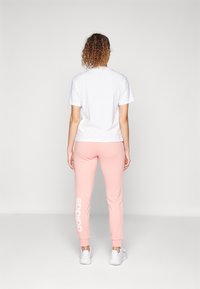 adidas Sportswear ESSENTIALS LINEAR CUFFED - Treniņtērpa apakšdaļas - semi pink spark