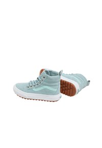 Hoge sneakers van lichtblauw suede met witte rubberen zolen. Kenmerken zijn onder andere een ronde neus, vetersluiting aan de voorkant en een getextureerde tan rubberen buitenzool.