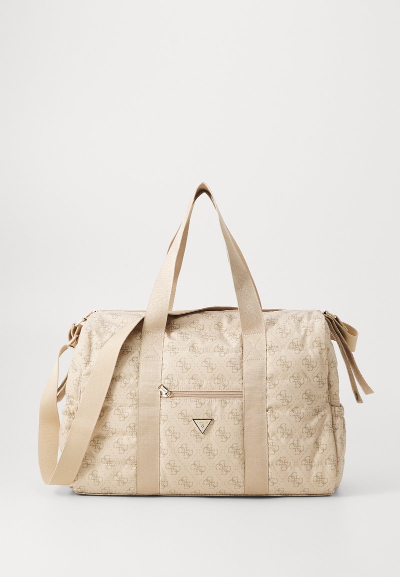 Beige quiltet duffel bag med et logomønster, to håndtak på toppen, en avtakbar skulderrem og en frontlomme med glidelås.