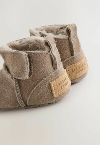 Bottes chevilles en daim gris avec doublure en fausse fourrure, sangle Velcro et détail en liège étiqueté "Little Loved" sur le talon.