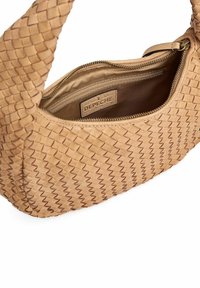 Borsa a tracolla in pelle beige intrecciata con chiusura a zip e foderatura in tessuto. Presenta un'etichetta del marchio all'interno e un design con manico curvato.