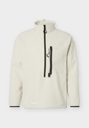 Off-weiße Pulloverjacke mit hohem Kragen, schwarzem vertikalem Reißverschluss der Brusttasche und schwarzem Hauptreißverschluss vorne mit Zuglaschen.