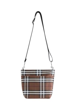 Brun, sort og hvid ternet crossbody taske med justerbar sort rem og foran lomme, hængende mod en hvid baggrund.