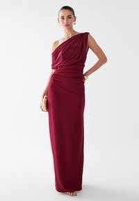 Bordo atklātām plecu kleitā, izgatavota no drapēta auduma ar ruched apdari un grīdas garuma dizainu, ar gludu tekstūru un elegantu siluetu.