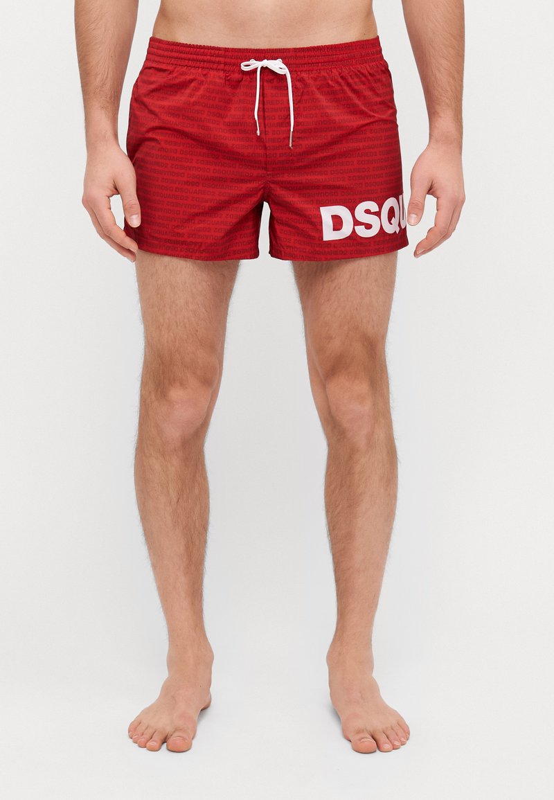 Røde badesort med hvit "DSQUARED" logo, laget av lett materiale, med elastisk midjebånd med snor og subtilt mønster.