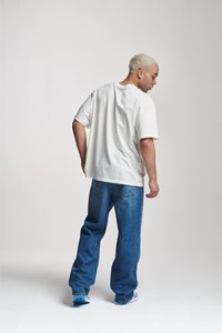 Løst sittende hvit bomull T-skjorte og mørkeblå denim jeans. Antrekket har en uformell design med rette ben og en avslappet silhuett.