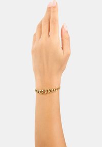 Braccialetto in catena d'oro su un polso, con anelli interconnessi e una finitura liscia e lucida. Design semplice che esalta l'aspetto del polso.