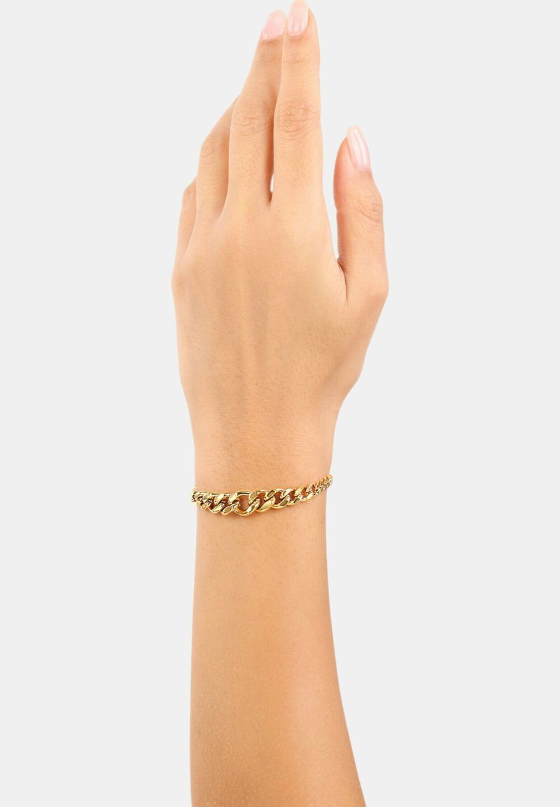 Braccialetto in catena d'oro su un polso, con anelli interconnessi e una finitura liscia e lucida. Design semplice che esalta l'aspetto del polso.