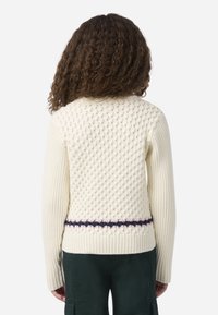 Εκρού πλεκτό πουλόβερ με υφή στην πλάτη, ριμπ μανίκια και ριγέ λεπτομέρεια σε ναυτικό μπλε και ανοιχτό ροζ στη μέση.