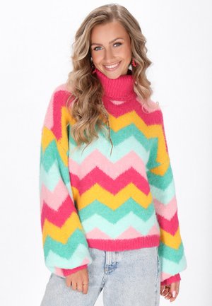 Pull en chevrons multicolores avec des rayures roses, jaunes et vertes menthe. Texture douce avec un col haut et des manches larges.