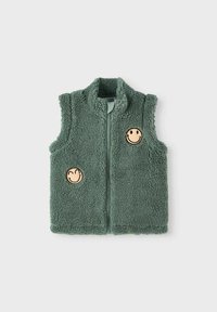 Vihreä fleece-liivi, jossa on korkea kaulus, kaksi hymyilevää naama-patchia ja etuvetoketju. Pehmeä rakenne ja hihaton muotoilu.