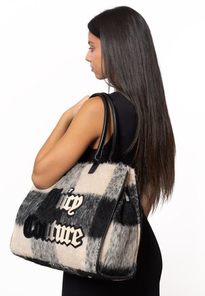 Borsa in pelliccia sintetica a quadri in bianco e nero con manici in pelle; presenta il logo ricamato "Juicy Couture" sul davanti.