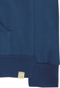 Felpa blu navy realizzata in cotone, con polsini a coste e un piccolo etichetta con logo e dettagli verdi sull'orlo. Texture liscia, design casual.